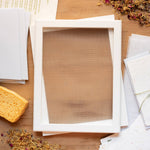 Wooden picture frame on a wooden surface with stationery items.