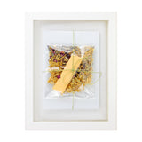 Framed artwork with a yellow leaf and dried flowers on a white background